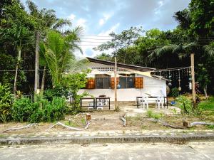 a small white house in front of a forest at CoCoCo in Ko Phayam