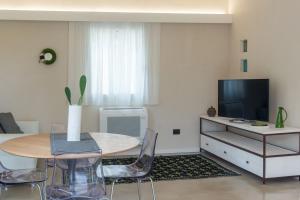Una sala de estar con una mesa y un televisor. en Villa Muxì, en Tortolì