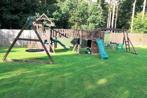 um parque infantil com dois baloiços num quintal em Hen & Stag Retreat Weekend Stay Sleeps 10 to 30 em Thetford