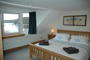 a bedroom with a bed and a large window at Harbourside in Tobermory