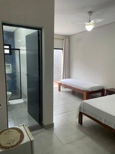 1 dormitorio con 1 cama y puerta corredera de cristal en Pousada Favo de Mel - Unidade 2 en Guarujá
