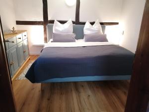 a bedroom with a large bed with white pillows at Reetmeer Apartments in Boiensdorf