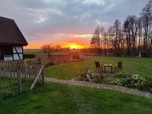 a sunset in a yard with a table and chairs at Reetmeer Apartments in Boiensdorf