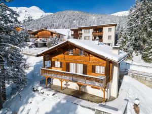 uma cabana de madeira na neve com montanhas ao fundo em Chalet Soldanella by Arosa Holiday em Arosa