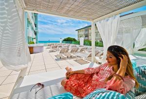 a young girl sitting on a hammock on the beach at Hotel Montecarlo in Bibione
