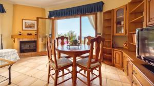 ein Esszimmer mit einem Tisch, Stühlen und einem TV in der Unterkunft Costacabana - Villa Cleo in Lloret de Mar