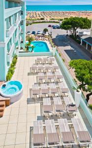 an aerial view of a resort with a pool and chairs at Hotel Montecarlo in Bibione