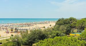 a beach with a large crowd of people at Hotel Montecarlo in Bibione