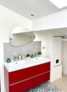 a bathroom with a red and white sink and a mirror at Amy 4 in Tarascon