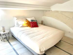 un letto bianco con cuscini sopra di Amy 4 a Tarascona