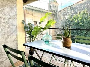 a table and two chairs on a balcony with plants at Amy 4 in Tarascon