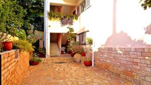 a house with a brick walkway with potted plants at Villa Maria in Parga