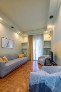 uma sala de estar com um sofá e 2 camas em City Haven: 1-BR, Central Athens em Atenas
