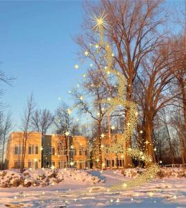 Un edificio coperto di luci natalizie nella neve di Chalets Multivoile 4 Saisons a Trois-Rivières