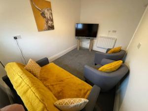 a living room with a couch and a tv at Lovely Apartment in Cleethorpes (sleeps up-to 10) in Cleethorpes