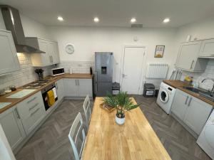 a kitchen with a wooden table with a plant on it at Lovely Apartment in Cleethorpes (sleeps up-to 10) in Cleethorpes