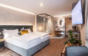 a bedroom with a large bed and a flat screen tv at Glanz & Glory Sölden in Sölden