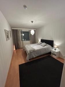 een slaapkamer met een groot bed en een zwart tapijt bij Keskustan tilava kaksio in Rovaniemi