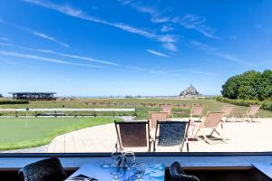 Elle offre une vue sur une terrasse dotée de chaises et d'une table. dans l'établissement Le Relais Saint Michel, au Mont-Saint-Michel