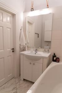 y baño con lavabo, espejo y bañera. en Beautiful, spacious apartment! Free Private Parking en Riga