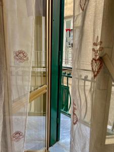 d'une fenêtre ouverte avec des rideaux sur le balcon. dans l'établissement BlessingNarrowStreet95, à Naples