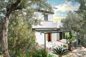 a white house with a patio and trees at GOCCE VILLAS - Casa Maradona in Nerano