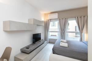 - une chambre avec un lit et une télévision dans l'établissement MagnoliaApartments - 16 Meravigli Duomo, à Milan