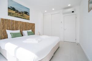 1 dormitorio blanco con 1 cama blanca grande en Paradise Villa, en Mariquiteira