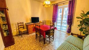 a living room with a table and chairs and a television at Appartamento La Gare - Affitti Brevi Italia in Bardonecchia