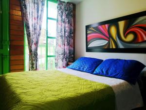 een slaapkamer met een bed met een schilderij aan de muur bij Orquidia 12 in Salento