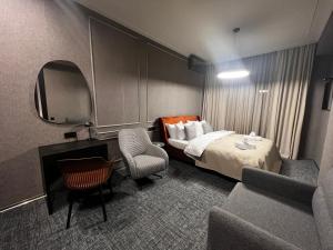 ein Hotelzimmer mit einem Bett und einem Stuhl in der Unterkunft Apart leitmotif in Tbilisi City