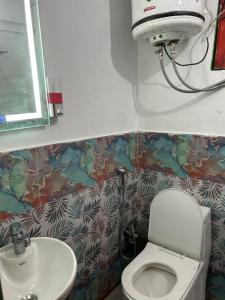 a bathroom with a toilet and a sink at Tiny Spot Hostel in Manāli