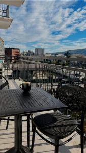 einen Tisch und Stühle auf einem Balkon mit Stadtblick in der Unterkunft Apart leitmotif in Tbilisi City