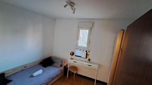 1 dormitorio con cama, escritorio y ventana en Acogedora Habitación Centro Bilbao, en Bilbao