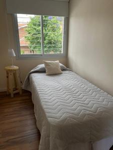 ein Bett in einem Schlafzimmer mit einem großen Fenster in der Unterkunft Casa Cerro de las Rosas in Cordoba