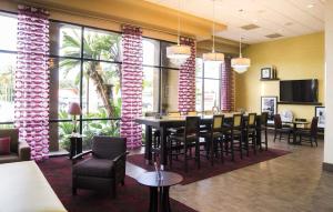 a dining room with a table and chairs and windows at Orlando Palms in Orlando