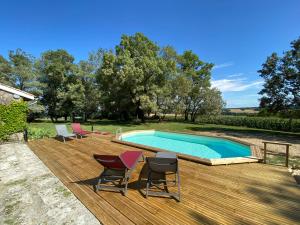 una terraza de madera con sillas y una piscina en Le Mas d'Henriette, en Leyritz-Moncassin