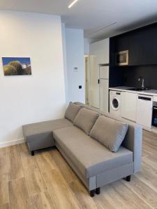 ein Sofa im Wohnzimmer mit Küche in der Unterkunft Exyca Metropolitano in Madrid
