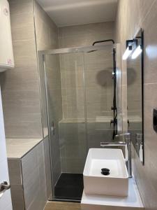 a bathroom with a shower and a white sink at Exyca Metropolitano in Madrid