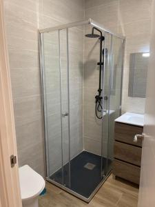 La salle de bains est pourvue d'une douche avec une porte en verre. dans l'établissement Exyca Metropolitano, à Madrid