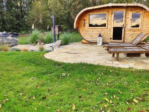 a wooden cabin with a bench in the grass at Reetmeer Apartments Spa & Reetdach am Salzhaff in Boiensdorf