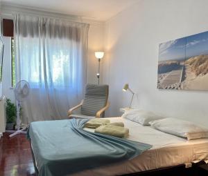 a bedroom with a bed and a chair and a window at Blife Julya private rooms in Faro