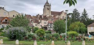 a large building with a castle in the background at maison Chez Kitoune in Éclans