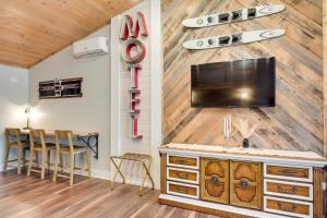 een kamer met een muur met een tv en surfplanken erop bij Cozy Tomahawk Studio On Harrison Hills Trails! in Tomahawk