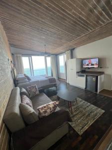 uma sala de estar com um sofá e uma televisão de ecrã plano em Sea View Cabin em Alexandria