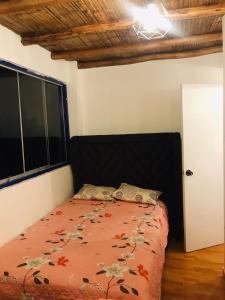 ein Schlafzimmer mit einem Bett mit einer roten Bettdecke und einem Fenster in der Unterkunft YAKY'S TOPARA in Jaguay