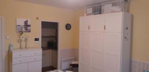 a kitchen with white cabinets and a clock on the wall at Studio Algarve in Middelkerke +35 photos