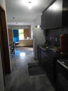 eine Küche mit einem Kühlschrank und ein Wohnzimmer in der Unterkunft Casa de praia com piscina em Governador Celso Ramos in Governador Celso Ramos + 10 Fotos