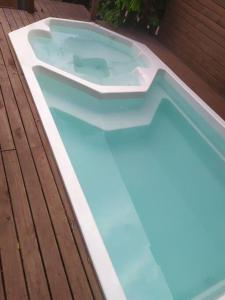 einem Whirlpool auf einer Holzterrasse in der Unterkunft Casa de praia com piscina em Governador Celso Ramos in Governador Celso Ramos