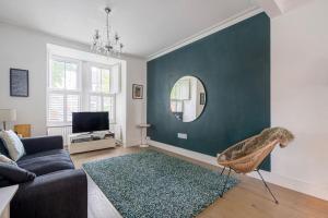 sala de estar con sofá y espejo en Cosy tranquil semi-detach house, en Beckenham